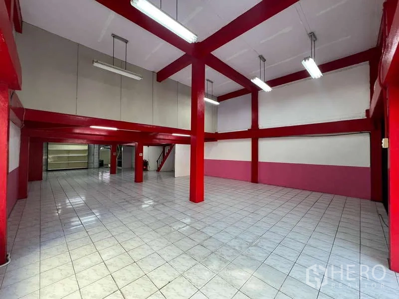 อาคารพาณิชย์ ให้เช่าในSuan Luang, Bangkok - โถงโชว์รูมเพดานสูง เสาเหล็กสีแดง พื้นกระเบื้องสีขาว และไฟแขวน