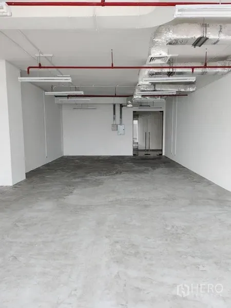 Office Space for rent in Sathon, Bangkok - Open-plan office shell with ducted air-conditioning, sprinkler pipes, LED lights and a glass entry door.