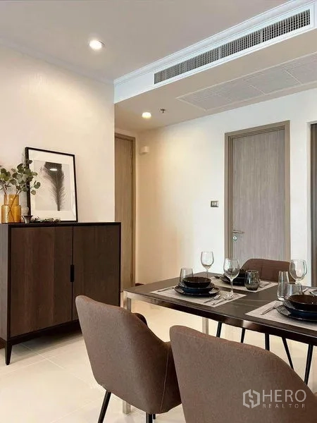 คอนโด ให้เช่าในWatthana, Bangkok - มุมรับประทานอาหาร โต๊ะจัดเซ็ต เก้าอี้บุนวม ตู้บัฟเฟต์สีเข้ม และกรอบภาพ