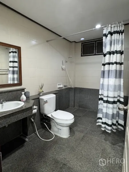บ้าน ให้เช่าในMin Buri, Bangkok - ห้องน้ำเคาน์เตอร์แกรนิต โถสุขภัณฑ์ และโซนอาบน้ำพร้อมผ้าม่านลายทาง