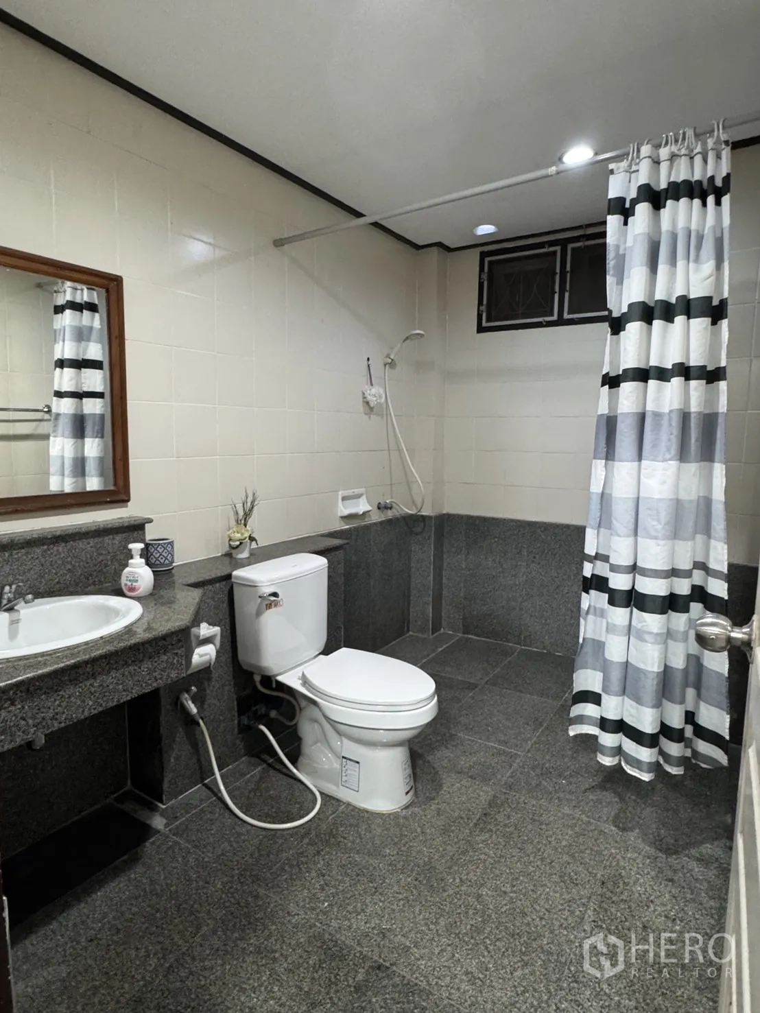 บ้าน ให้เช่าในMin Buri, Bangkok - ห้องน้ำเคาน์เตอร์แกรนิต โถสุขภัณฑ์ และโซนอาบน้ำพร้อมผ้าม่านลายทาง