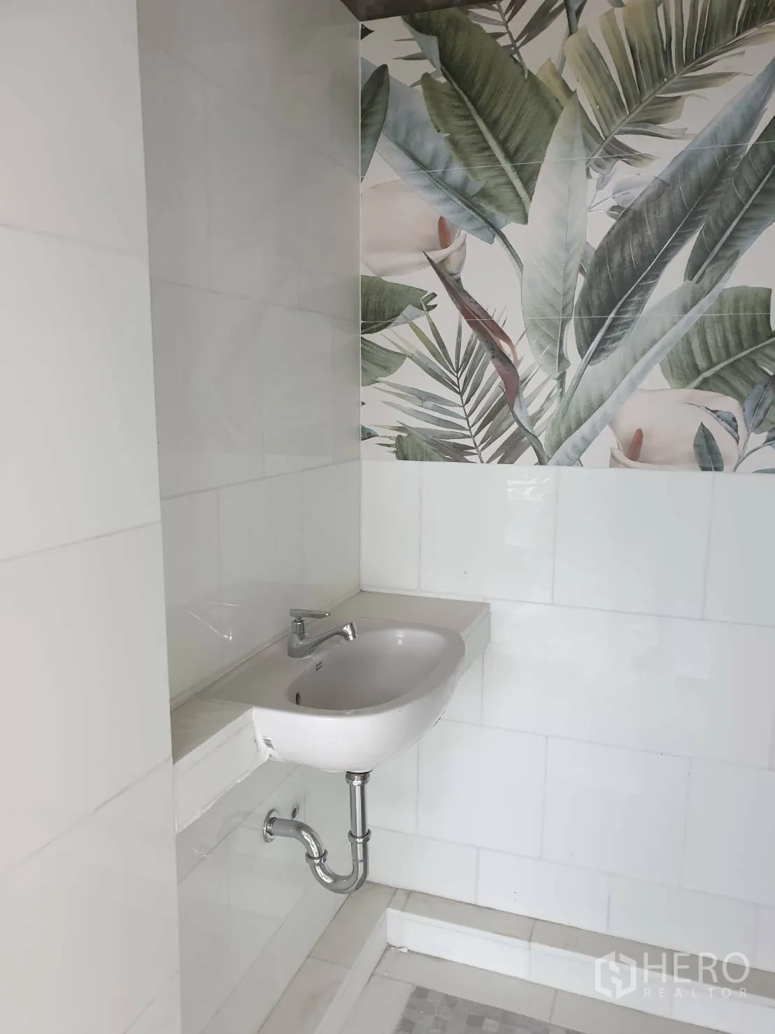 Office Space for rent or sale - Restroom area with wall-mounted basin and decorative botanical tiles.