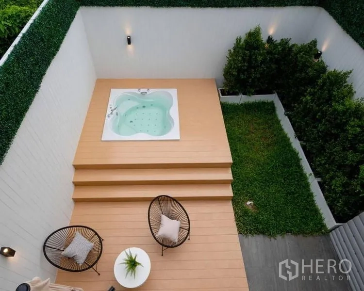 联排别墅 出售在Khlong Toei, Bangkok - 私家庭院，木平台上设有升起式按摩浴缸，休闲座椅与草坪。