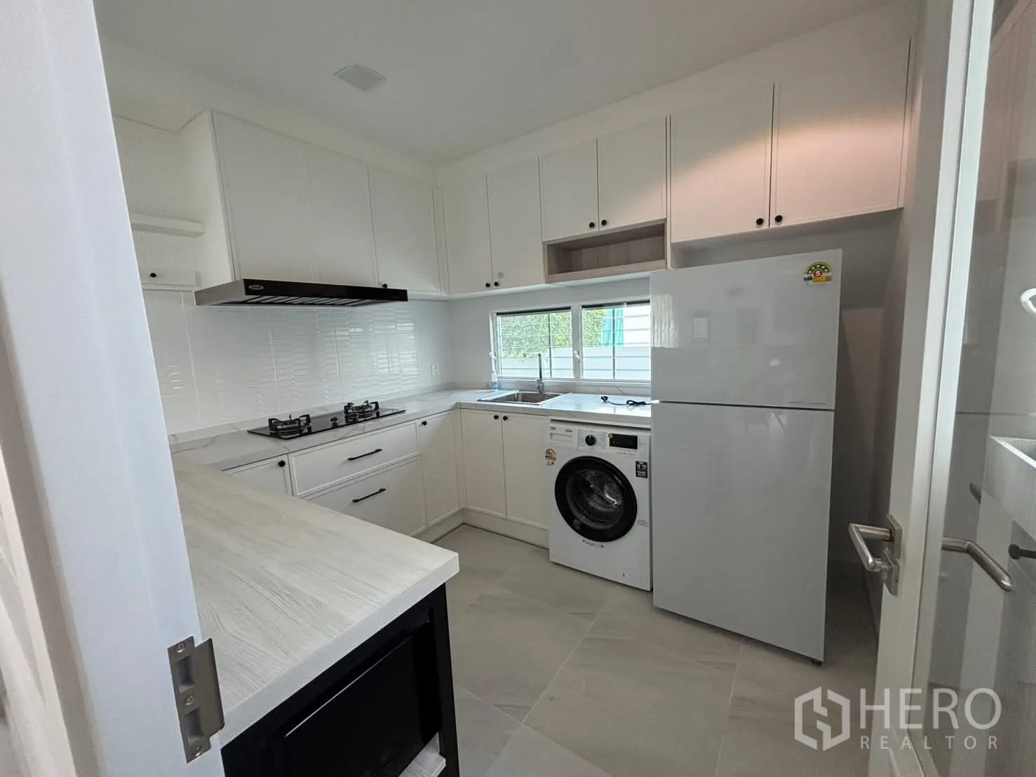 独栋房屋 for rent in Bang Phli, Samut Prakan - 白色整体厨房，带燃气灶、油烟机、冰箱与洗衣机。
