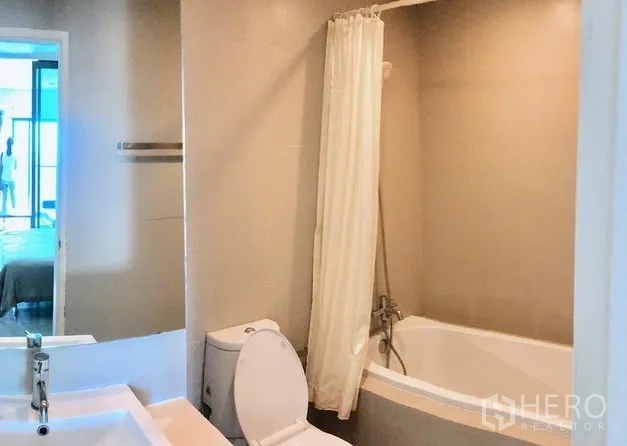 公寓 出租在Khlong Toei, Bangkok - 浴室配浴缸与浴帘、坐便器和双台盆洗手台