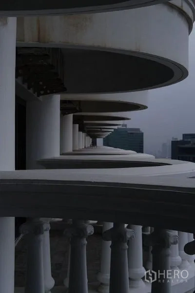 公寓 出租在Bang Rak, Bangkok - 高层外立面，弧形阳台与古典栏杆。