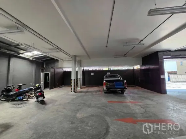 พื้นที่ขายปลีก ให้เช่าในKhlong Toei, Bangkok - พื้นที่จอดรถชั้นล่างในร่ม พื้นคอนกรีต ไฟเพดาน พร้อมมอเตอร์ไซค์และรถกระบะ