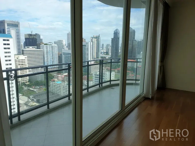 Condominium for rent in Watthana, Bangkok - Private balcony beyond sliding glass doors offering panoramic Bangkok skyline views from a high floor.