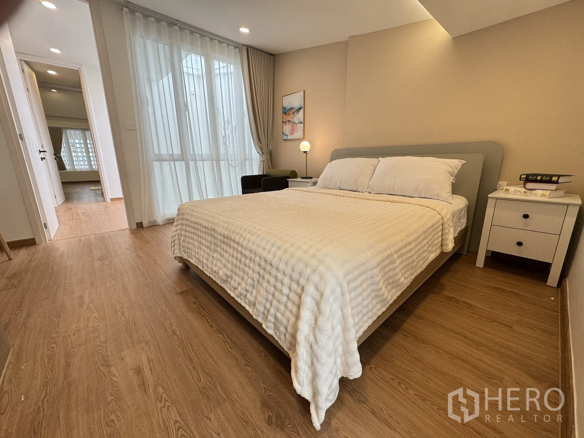 联排别墅 出售 - 卧室配大窗与柔和灯光，木地板。