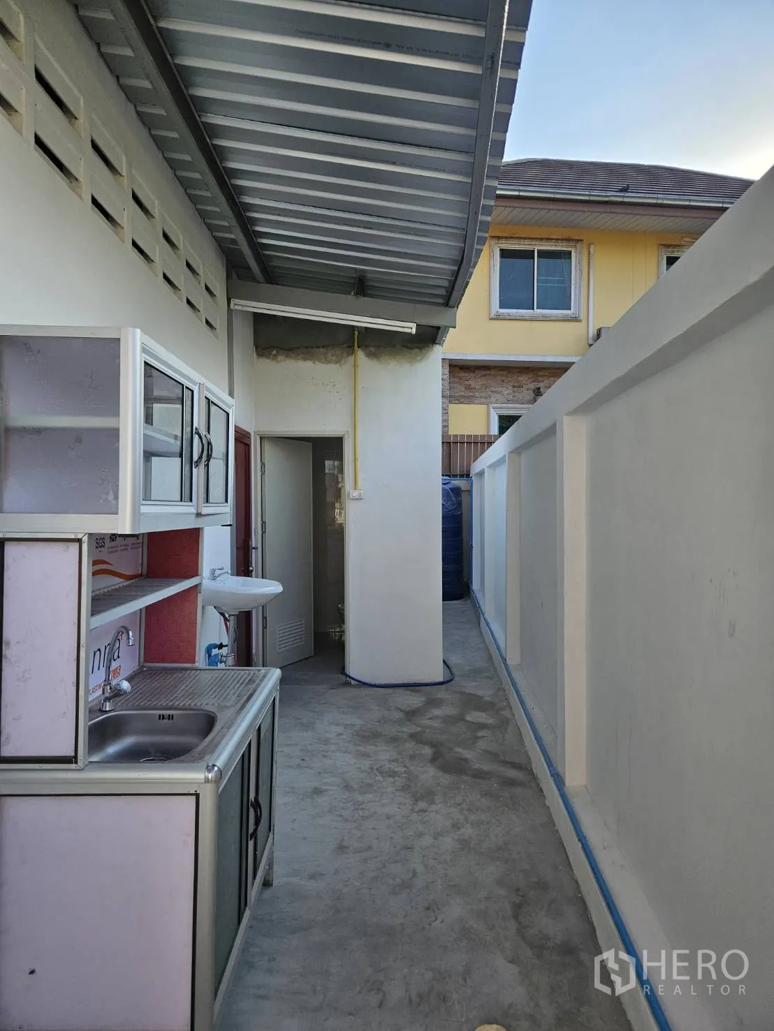 โกดัง for rent in Mueang Samut Prakan, Samut Prakan - ทางเดินด้านข้างมีหลังคาพร้อมอ่างล้างมือและประตูเข้าห้องน้ำ