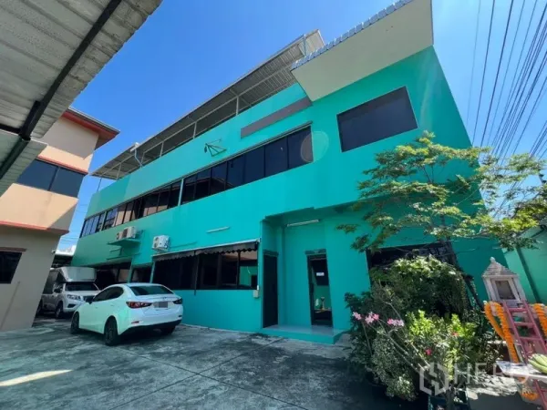 工厂 出售在Wang Thonglang, Bangkok - 主厂房立面，两层大窗，外墙空调机与小花园。