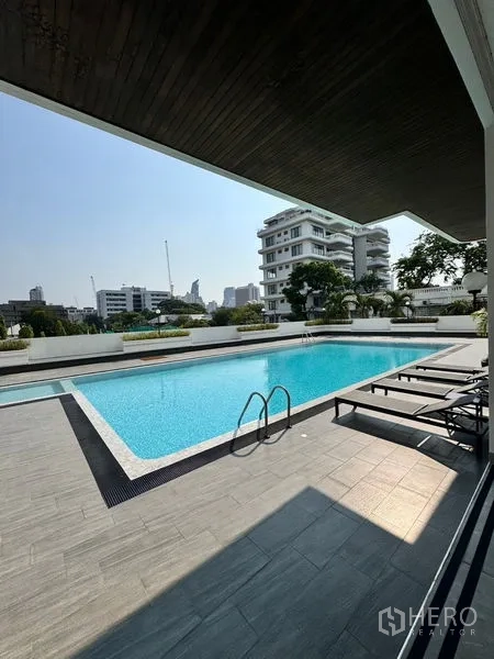 อพาร์ทเมนท์ ให้เช่าในKhlong Toei, Bangkok - สระว่ายน้ำกลางแจ้งขนาดใหญ่พร้อมเตียงอาบแดด และวิวอาคารโดยรอบ