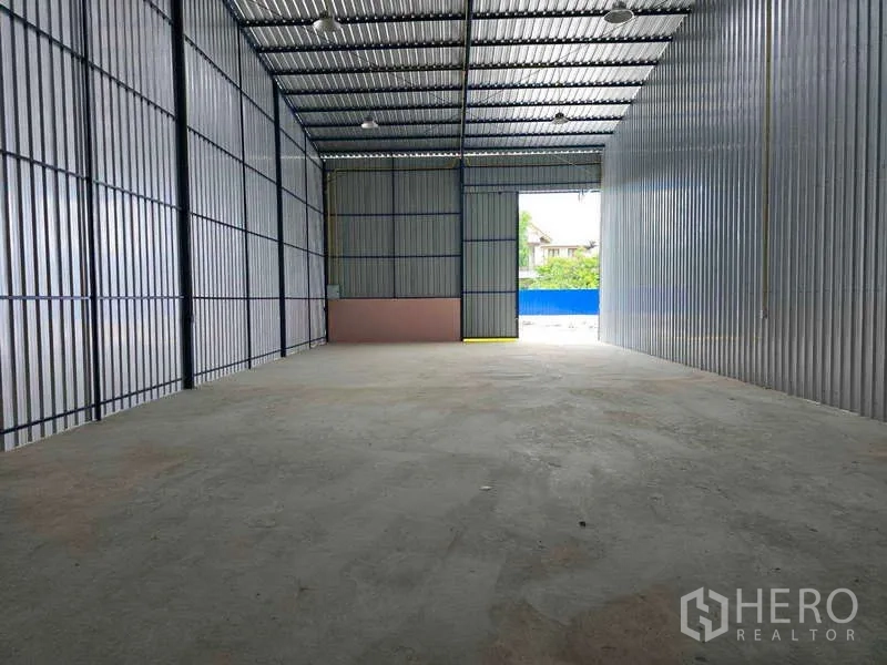 คลังสินค้า ให้เช่าในKhlong Toei, Bangkok - อ่าวโกดังลึก มองเห็นช่องเปิดด้านหน้าและรั้วสีน้ำเงินภายนอก