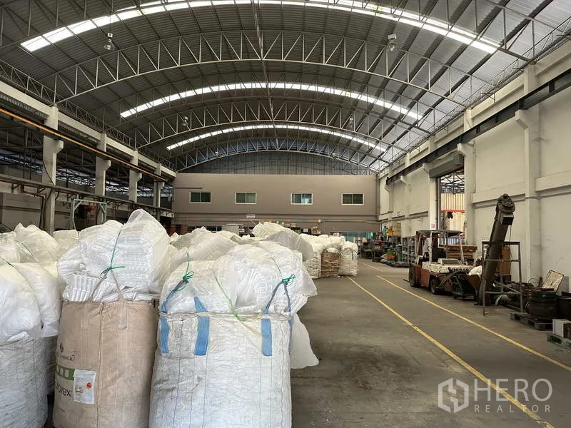 Factory for rent or sale in Khlong Luang, Pathum Thani - Spacious factory aisle beneath a curved roof with internal mezzanine windows.