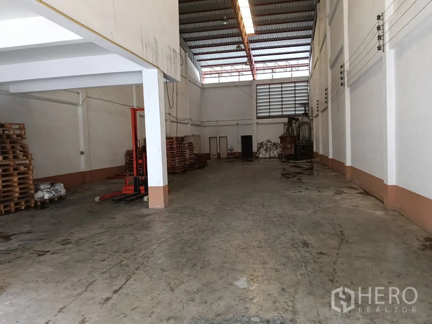 Factory for rent or sale in Bang Phae, Ratchaburi - Open warehouse area with pallets, overhead lighting, and durable flooring.