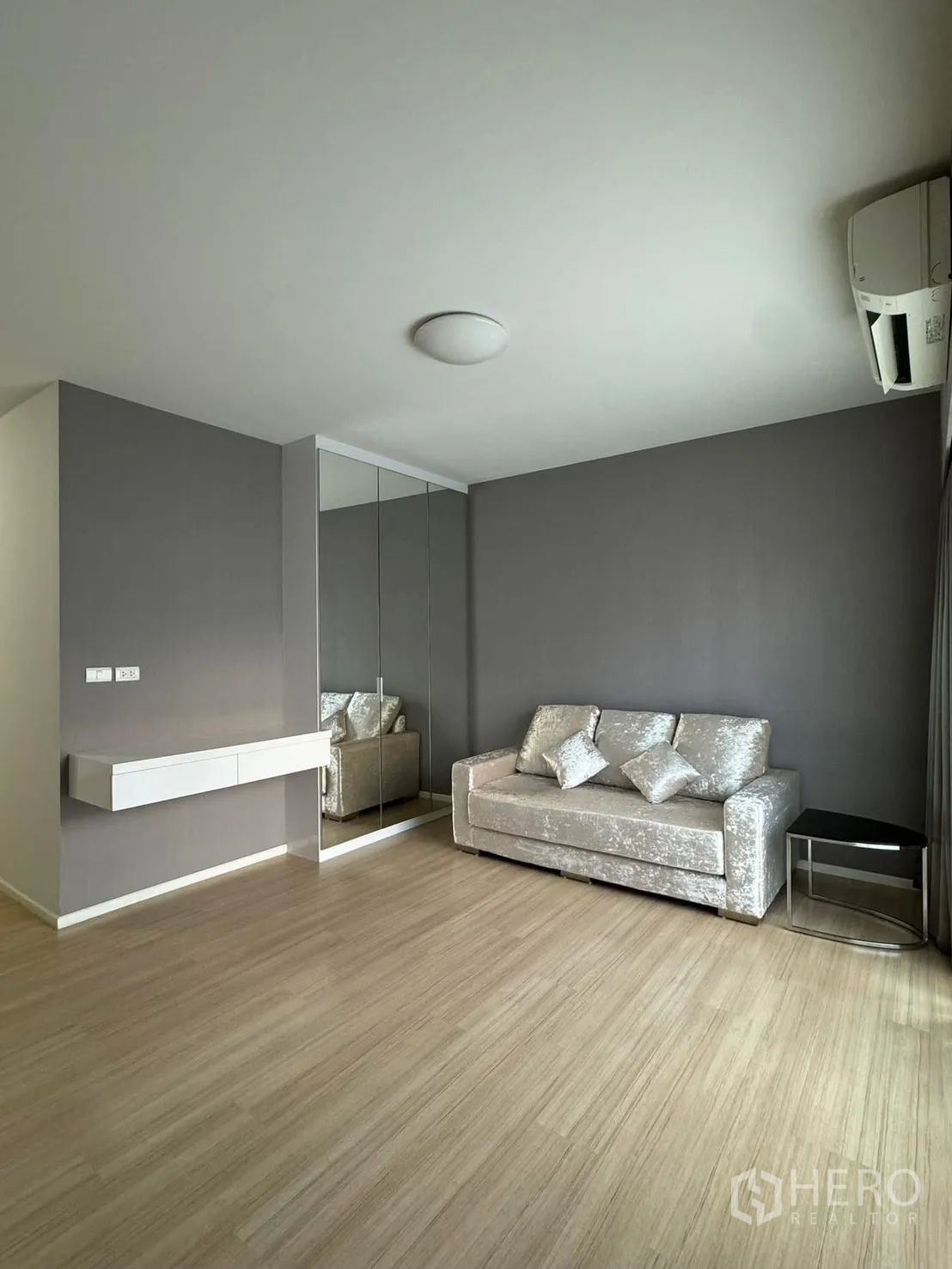 联排别墅 for rent in Suan Luang, Bangkok - 极简起居角：银色沙发、镜面衣柜与浅色木地板。