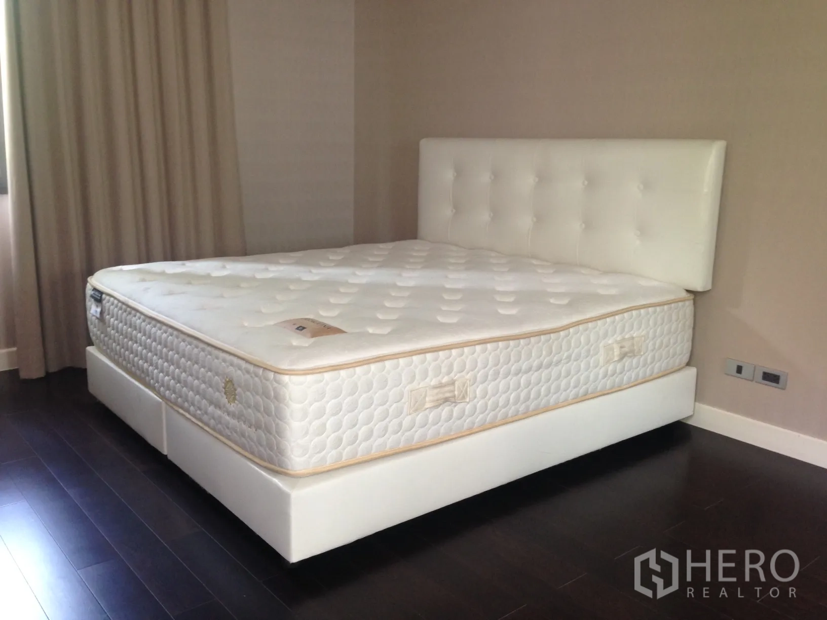 ทาวน์เฮาส์ ให้เช่าในBang Kapi, Bangkok - ห้องนอนพร้อมเตียงใหญ่บุหนังสีขาว พื้นไม้เข้ม และผนังโทนอบอุ่น