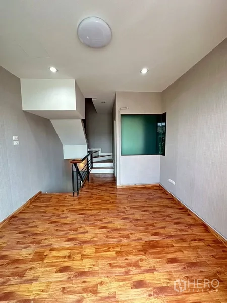 ทาวน์เฮาส์ ให้เช่าหรือขายในPhra Khanong, Bangkok - โถงชั้นบนพื้นไม้พร้อมหน้าต่างกระจกเข้ามุมและราวบันได