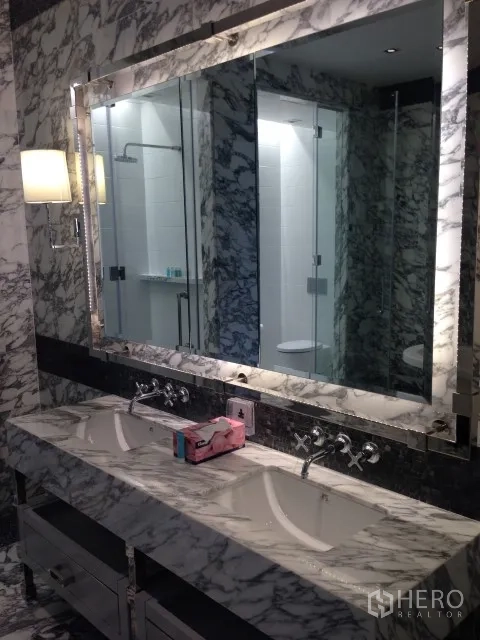 Condominium for rent or sale in Bang Rak, Bangkok - Marble bathroom with double vanity, oversized mirror and glass shower.