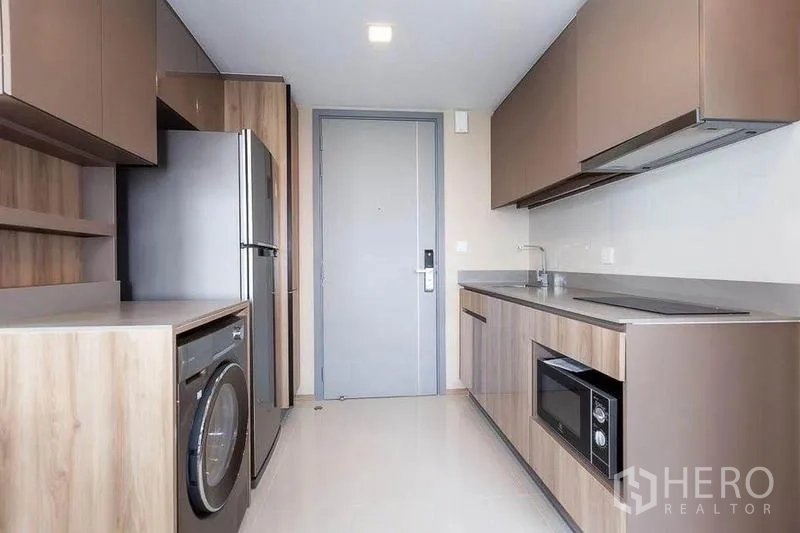 คอนโด ให้เช่าในWatthana, Bangkok - ครัวสไตล์แกลลีย์ บิลท์อินลายไม้ พร้อมตู้เย็น เครื่องซักผ้า ซิงก์ และเตา-ไมโครเวฟ