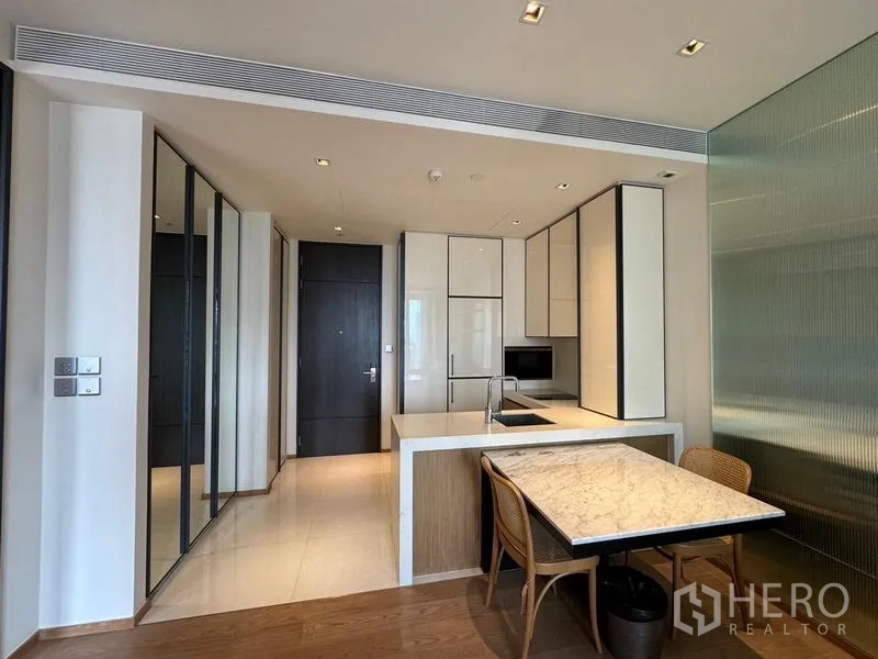 คอนโด ให้เช่า - ครัวขนาดกะทัดรัด มีไอส์แลนด์ โต๊ะทานหินอ่อน และตู้บิลต์อินเต็มผนัง