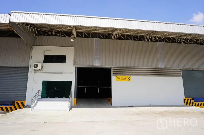 คลังสินค้า ให้เช่าในSi Racha, Chon Buri - ด้านหน้าโกดังสมัยใหม่พร้อมทางลาด บันได และประตูม้วน ระบุ Warehouse 3