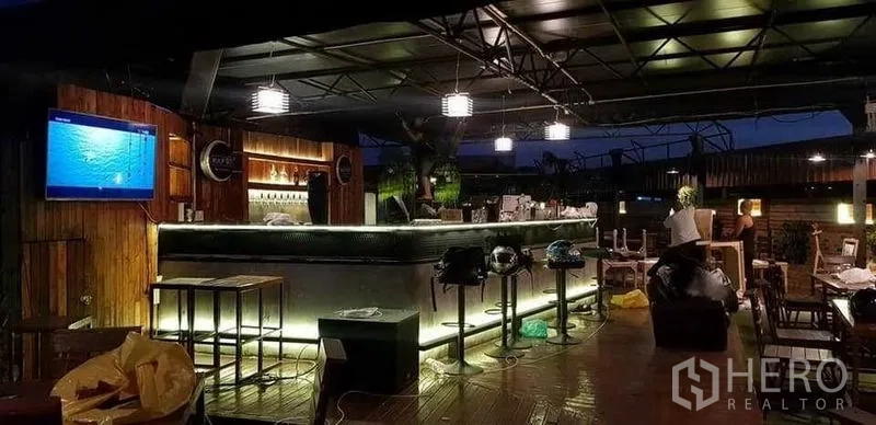 零售空间 出租在Khlong Toei, Bangkok - 近景现代屋顶吧台，高脚凳与吊灯设计。