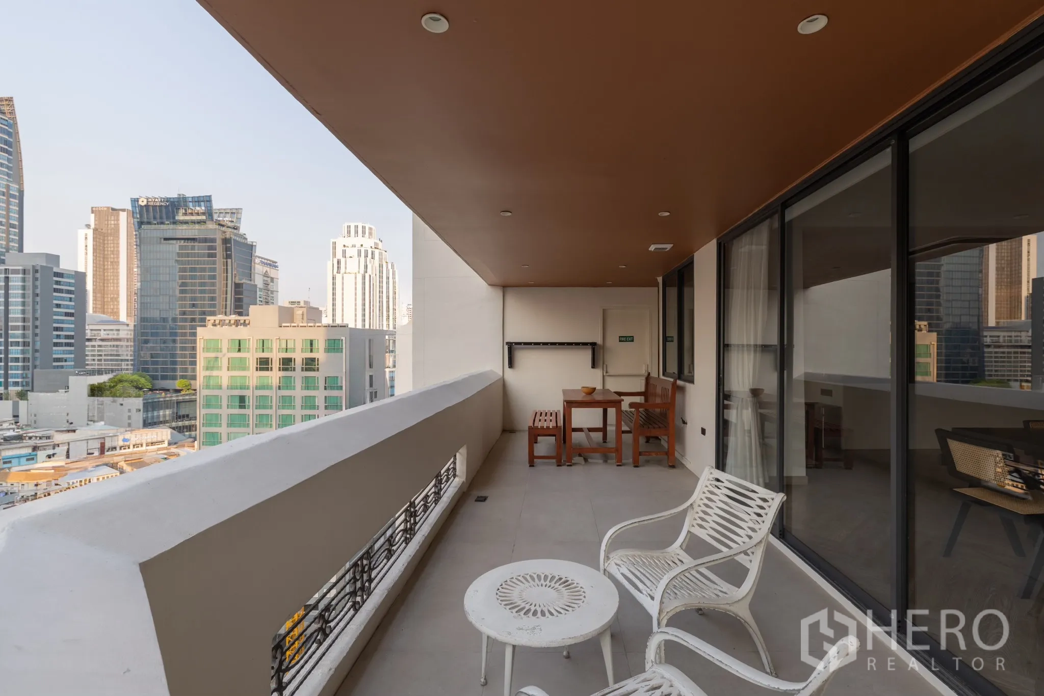Condominium for sale in Khlong Toei, Bangkok - Covered balcony with outdoor seating and skyline views of Bangkok high‑rises near Nana.
