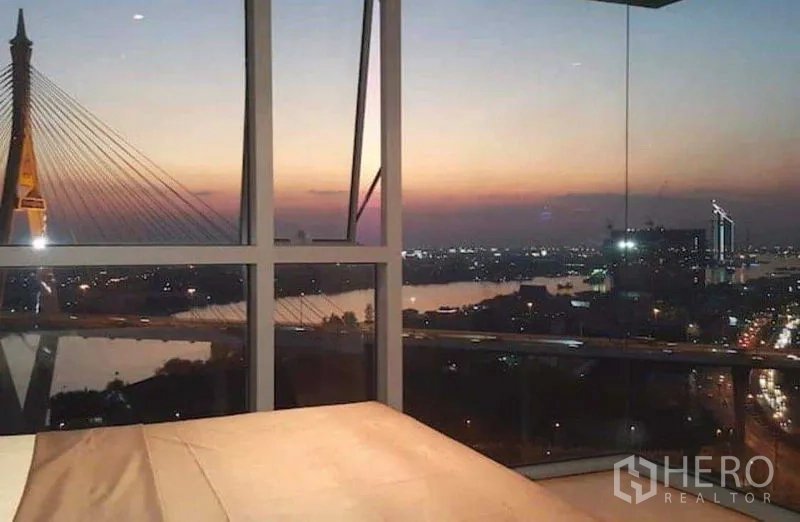 คอนโด ให้เช่าหรือขายในYan Nawa, Bangkok - วิวแม่น้ำและสกายไลน์ยามค่ำจากห้องนอนผ่านกระจกเข้ามุม