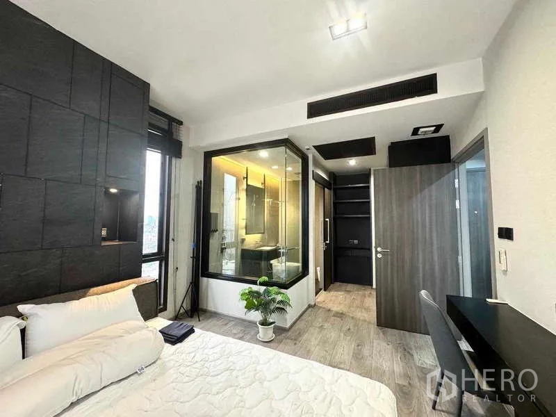 Condominium for rent - Master bedroom with a glass-enclosed bathroom, built-in wardrobe and a work desk.