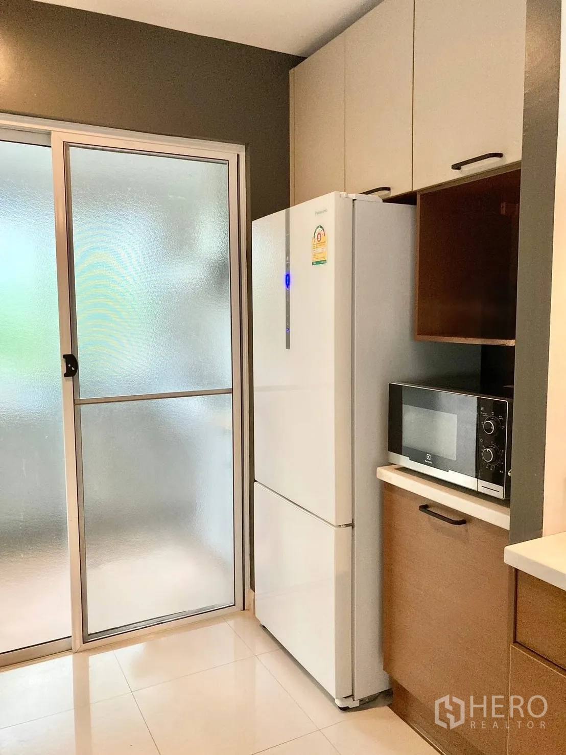 独栋房屋 for rent in Prawet, Bangkok - 备餐区配冰箱、微波炉与磨砂玻璃推门。