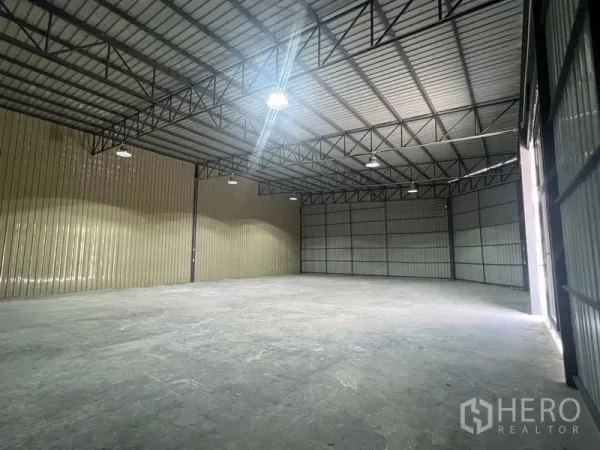 คลังสินค้า ให้เช่าในPhra Khanong, Bangkok - ภาพมุมกว้างภายใน แสดงพื้นที่โล่งขนาดใหญ่ โครงเหล็ก และประตูบานเลื่อน.