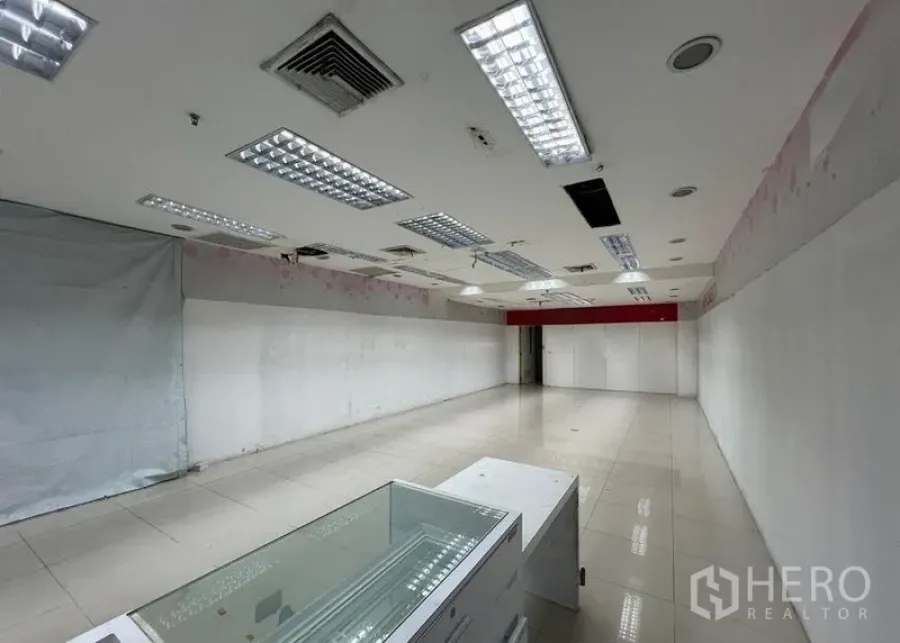 零售空间 出租 - 零售空间带玻璃展示柜、白色隔墙与嵌入式照明，开放式布局。