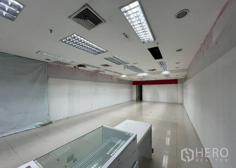 零售空间 出租 - 零售空间带玻璃展示柜、白色隔墙与嵌入式照明，开放式布局。