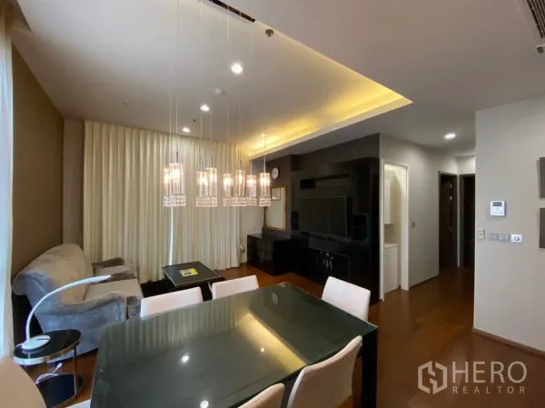 คอนโด ให้เช่าในWatthana, Bangkok - ห้องนั่งเล่นแบบโอเพ่นสเปซ พร้อมโคมไฟระย้า ฝ้าเพดานซ่อนไฟ และผนังบิลท์อินสำหรับทีวี