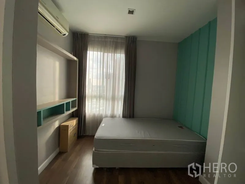 Condominium for rent in Watthana, Bangkok - Alternate view of the second bedroom with paneled teal wall, shelves and sheer curtains