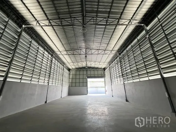 货栈 出租在Prawet, Bangkok - 仓库内部，高钢桁架屋顶，百叶通风墙，前方为出入口。