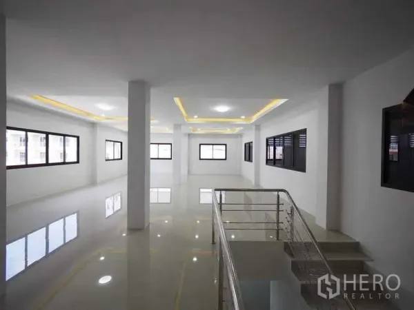 Warehouse for rent or sale in Krathum Baen, Samut Sakhon - Bright upper-floor office space with glossy tile floor, large windows and a stair railing.