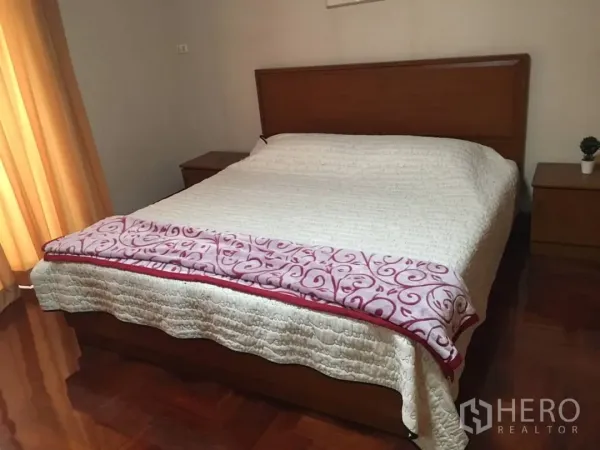 Condominium for rent in Watthana, Bangkok - Master bedroom with large bed, warm curtains and wooden flooring