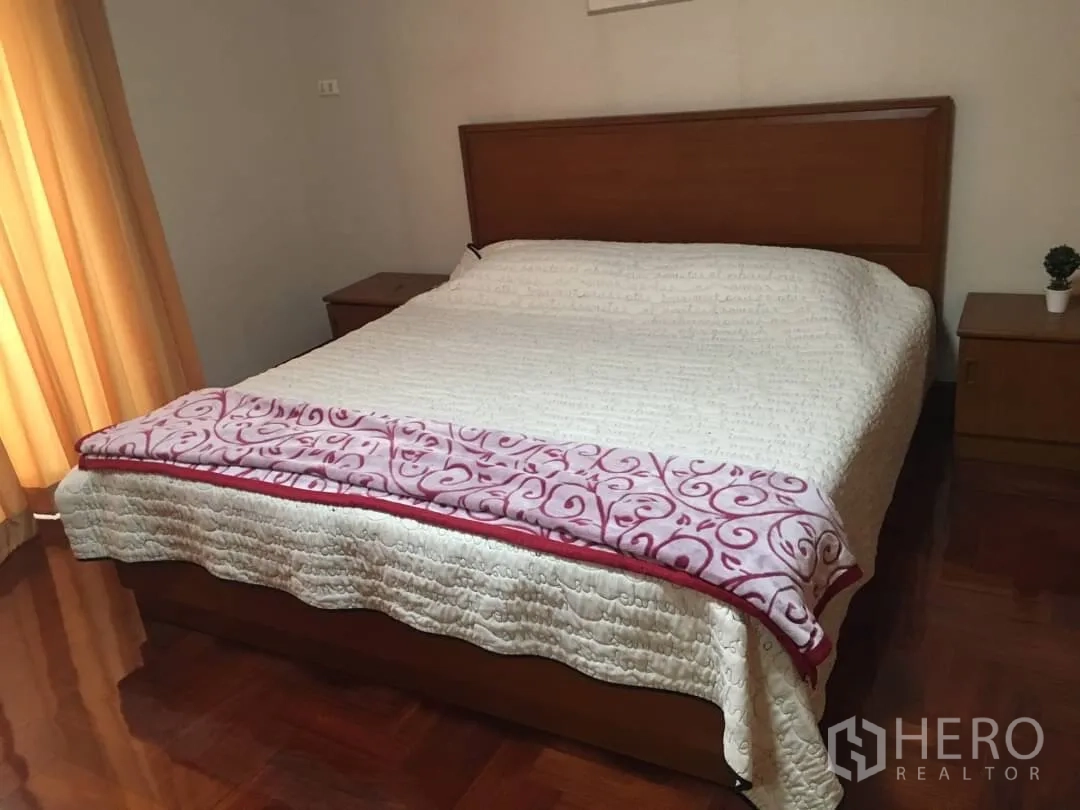 Condominium for rent in Watthana, Bangkok - Master bedroom with large bed, warm curtains and wooden flooring