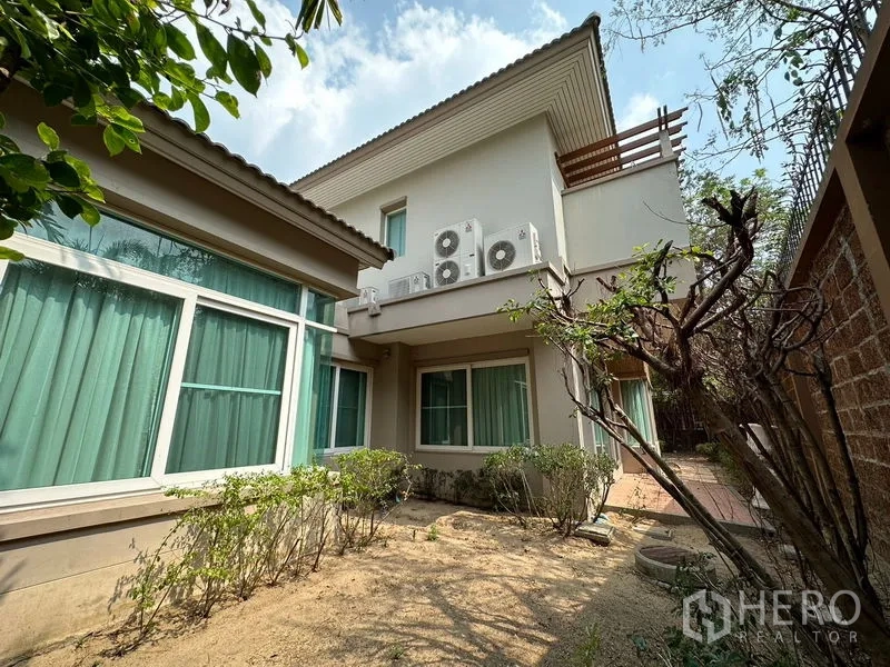 Detached House for rent or sale in Pak Kret, Nonthaburi - Side yard and rear exterior with multiple AC compressor units and windows.