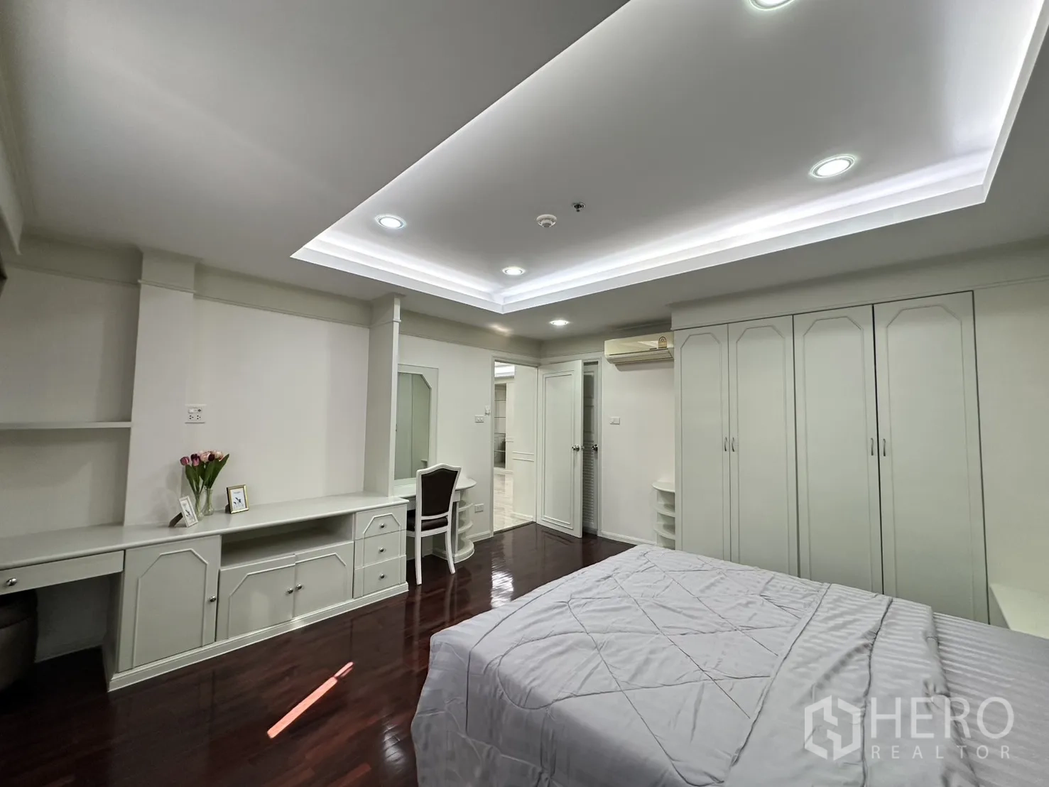 Condominium for rent in Watthana, Bangkok - Bedroom with study desk, wardrobes, and wood floor.