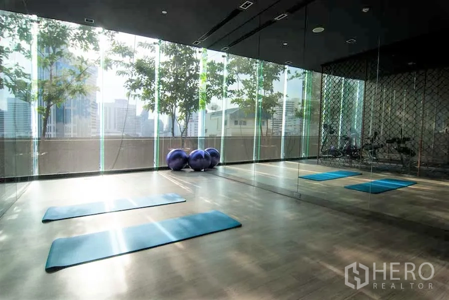 คอนโด ให้เช่าในWatthana, Bangkok - ห้องฟิตเนสและสตูดิโอโยคะแสงธรรมชาติ ผนังกระจกเงา เสื่อออกกำลังกาย และหน้าต่างสูงมองเห็นเมือง