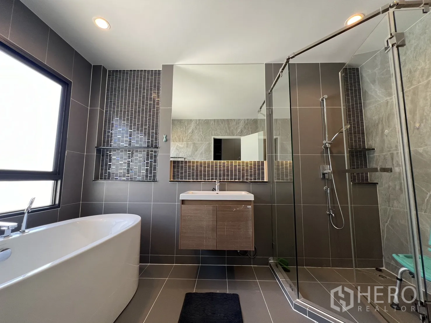 Detached House for rent or sale in Mueang Pathum Thani, Pathum Thani - Master bathroom with freestanding bathtub, glass shower and large mirror.