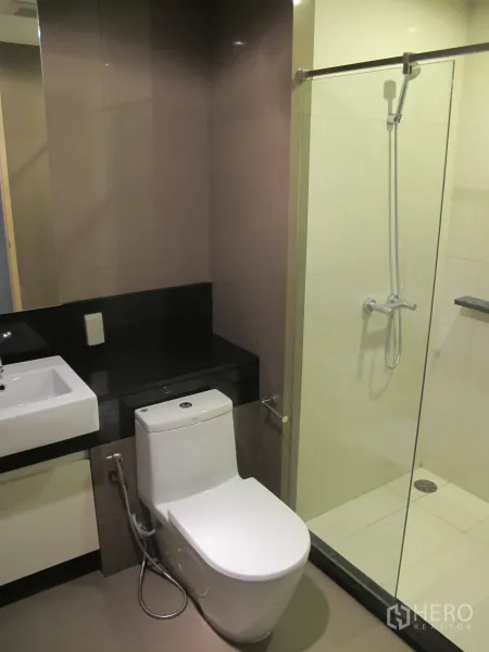 公寓 出租在Khlong Toei, Bangkok - 现代卫浴，玻璃淋浴间、坐便器与台上盆。