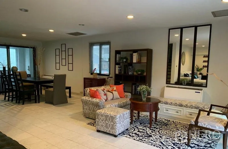 Townhouse for rent in Watthana, Bangkok - Open-plan living and dining room with recessed lighting and bookshelf.