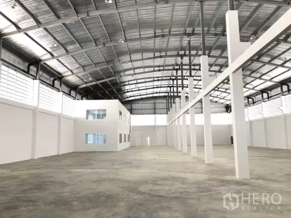 Warehouse for rent in Samut Prakan - Warehouse floor with tall support columns and an internal glazed office block.