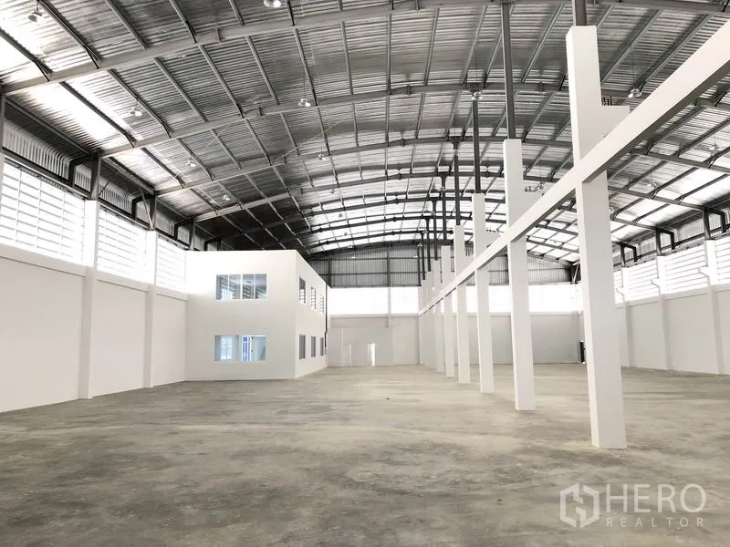 Warehouse for rent in Samut Prakan - Warehouse floor with tall support columns and an internal glazed office block.
