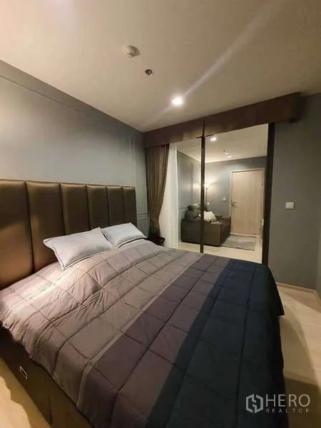Condominium for rent - One-bedroom with upholstered headboard and large glass partition to living room.