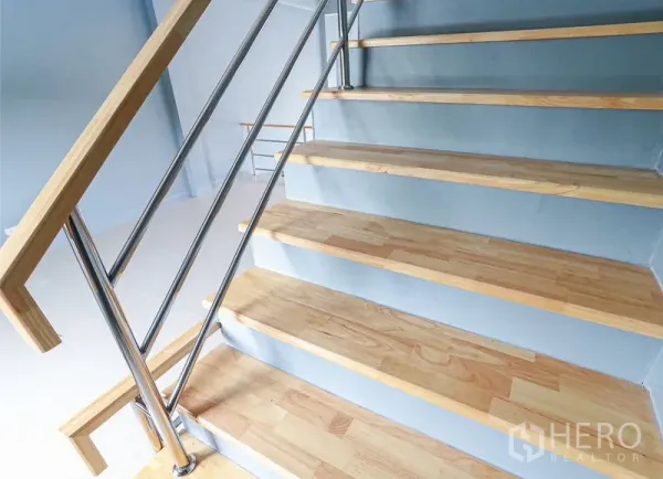 Shophouse for sale in Lam Luk Ka, Pathum Thani - Close-up of wood-tread stairs with a steel handrail in the shophouse.